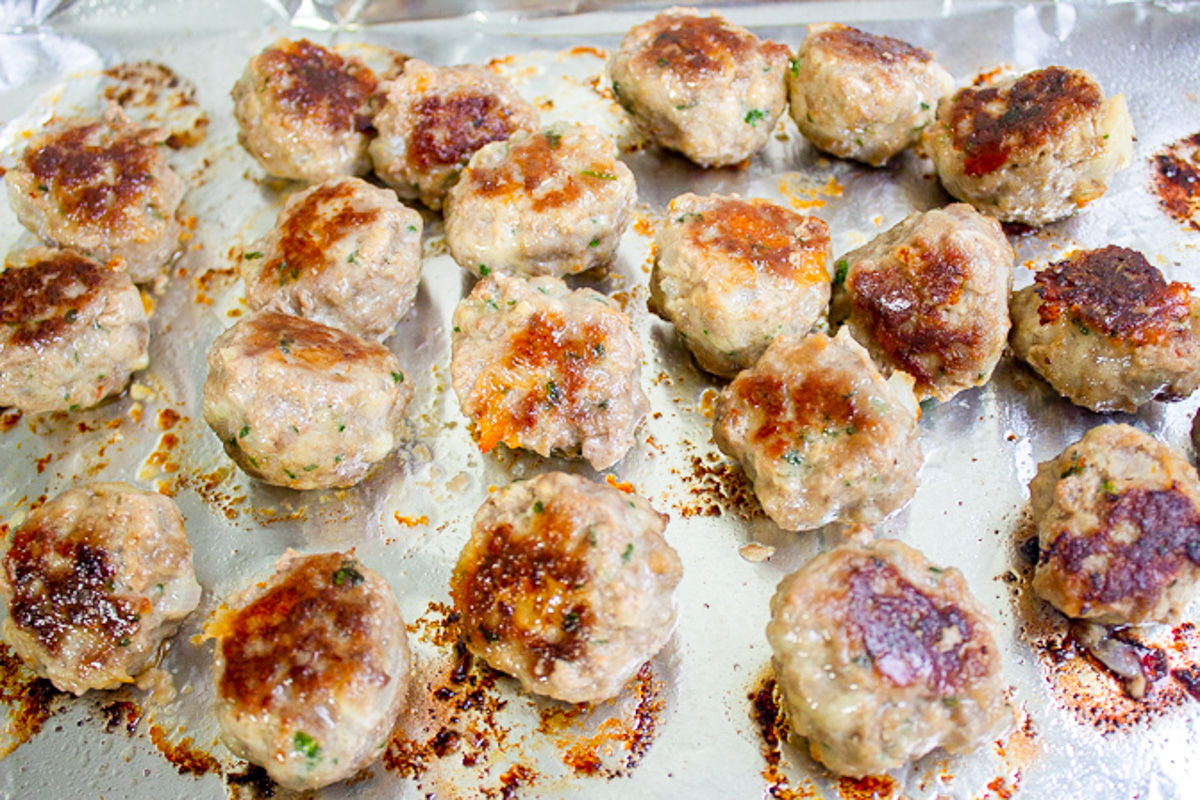 baked meatballs on lined baking pan.