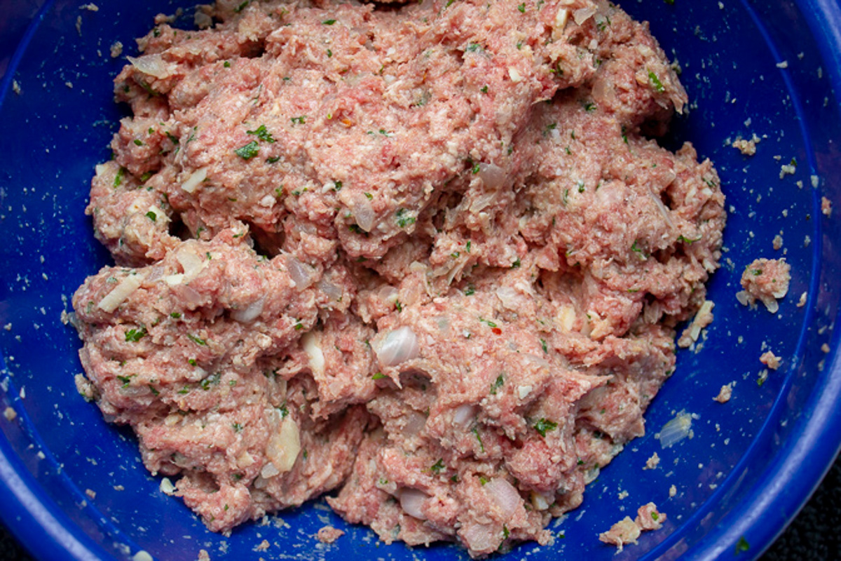 ground meat mixed with panade filling in blue bowl.