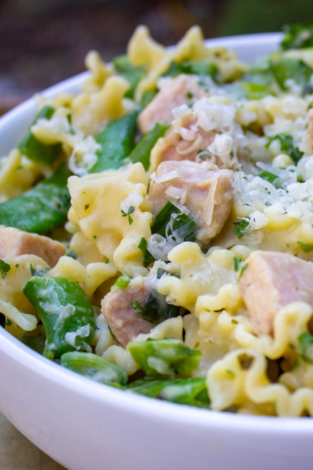 creamy pasta with peas and ham in bowl.