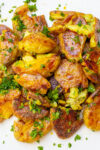 roasted smashed fingerling potatoes topped with gremolata on plate.