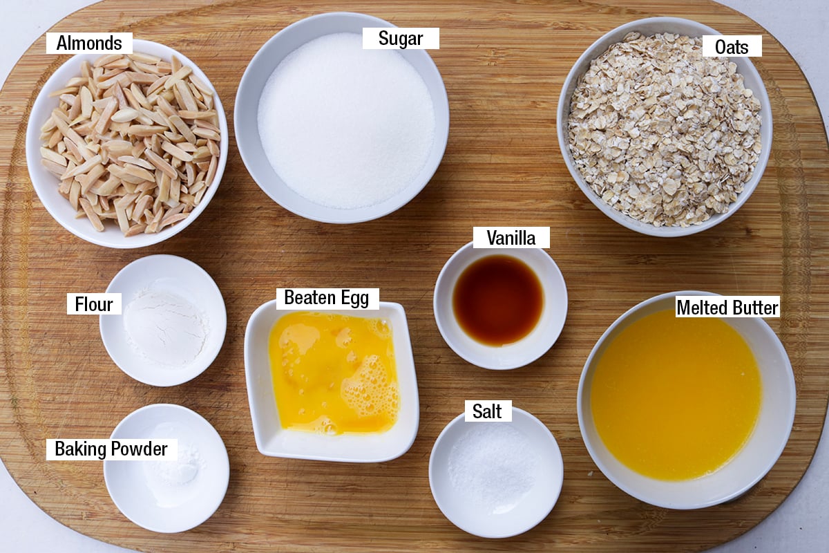 Oats, almonds, melted butter, sugar, flour, baking powder, beaten egg, salt, and vanilla extract.