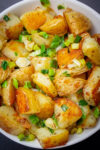 fried potatoes and onions in white bowl.
