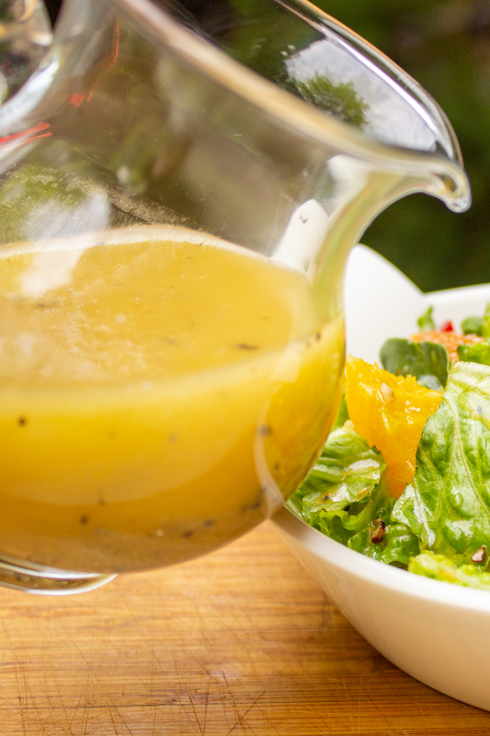 pitcher of honey lemon dressing. tipped over bowl of salad.