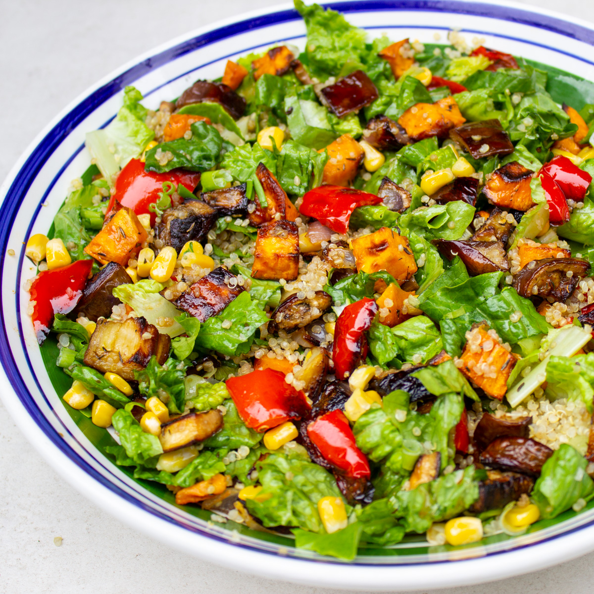 tossed roasted vegetable and quinoa salad in bowl.