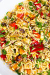 lemon orzo salad with grilled veggies in white bowl.