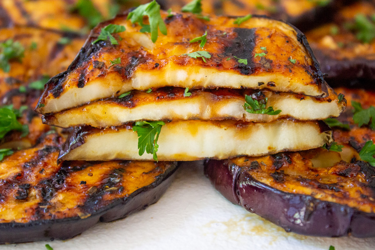 stack of eggplant cut up to see inside on cutting board.