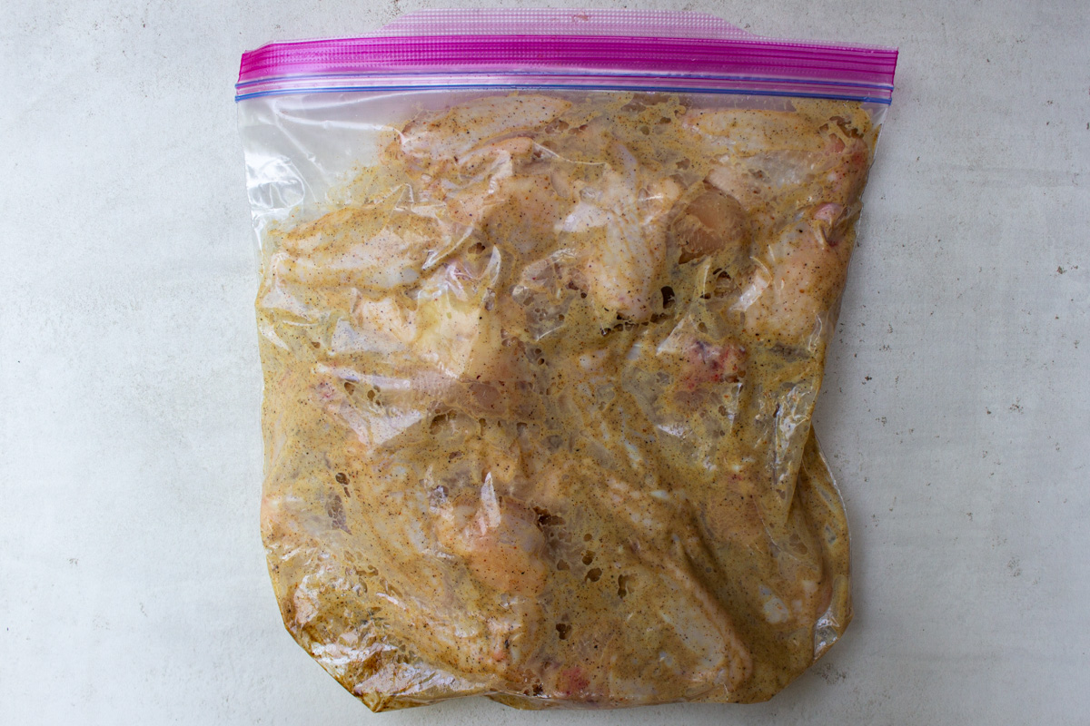 chicken wings with marinade in ziploc bag.