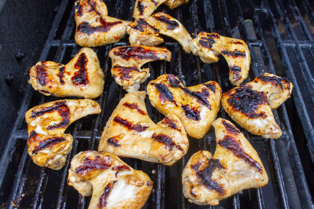 marinated chicken wings on grill cooking.