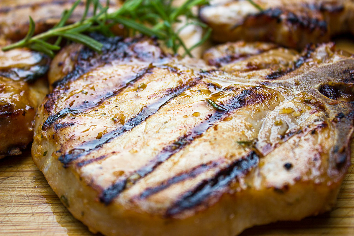 close up of marinated pork chop on cutting board.