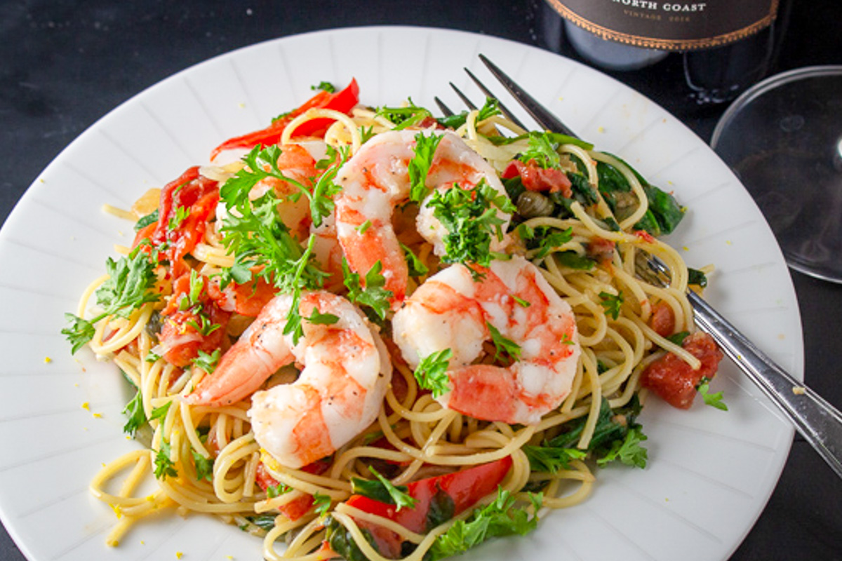 vegetable spaghetti topped with shrimp. 