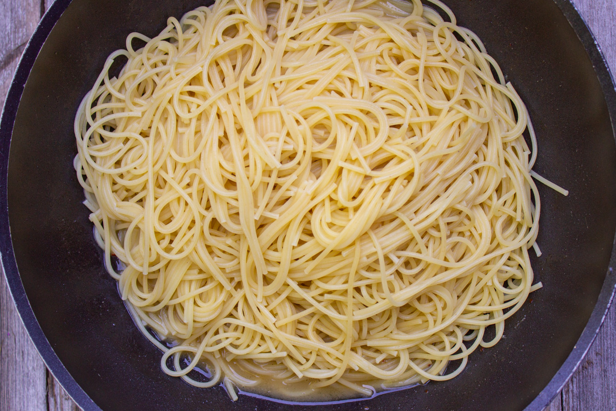 pasta in wine sauce in skillet.