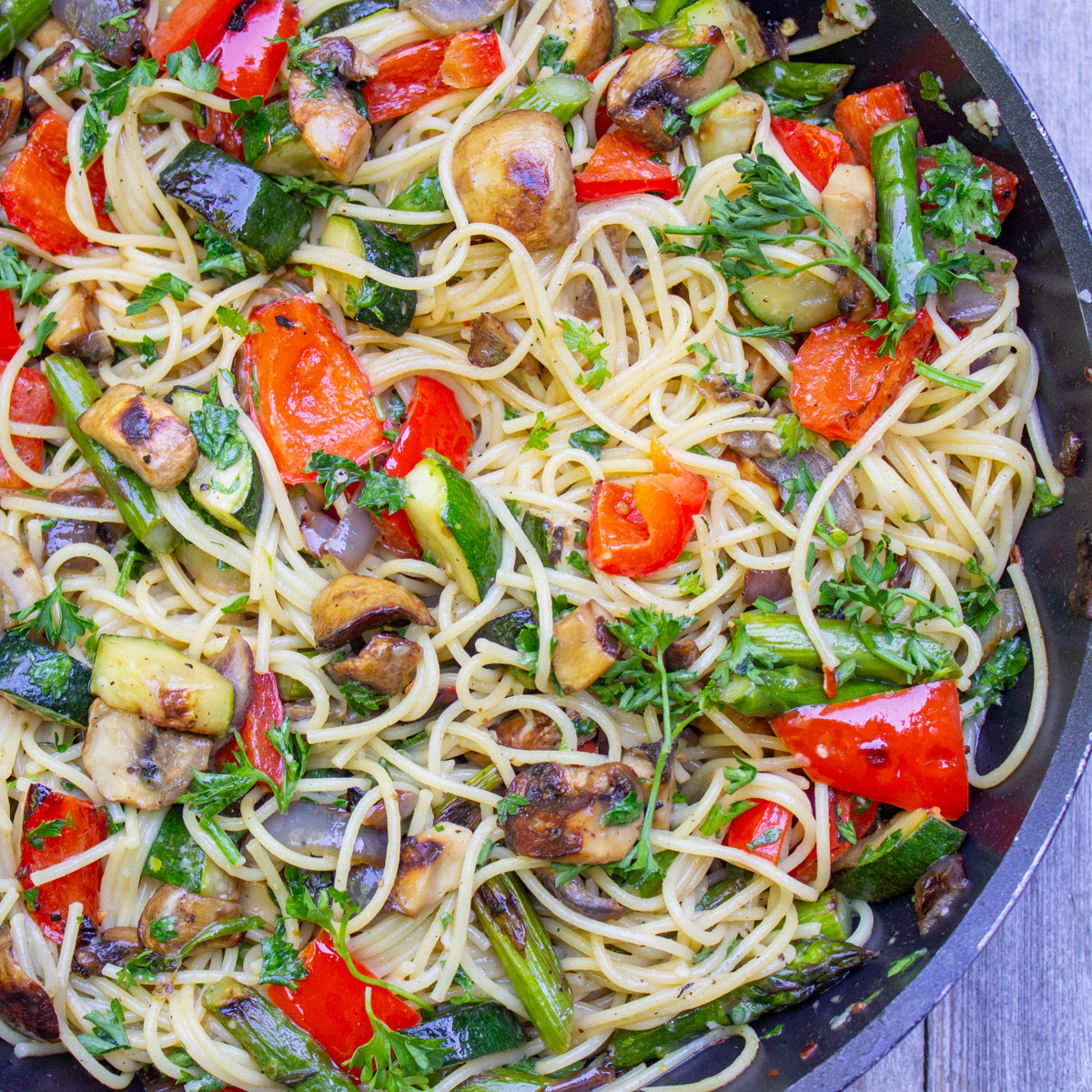 spaghetti with grilled veggies in wine sauce in skillet.