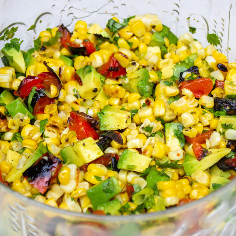 charred corn salad in a glass bowl garnished with cilantro.
