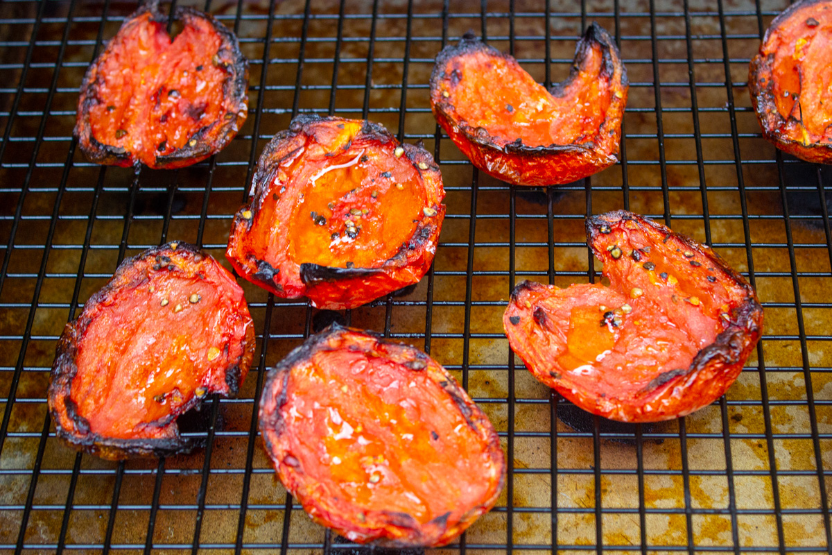 fire roasted tomatoes sitting on wire rack over baking sheet.