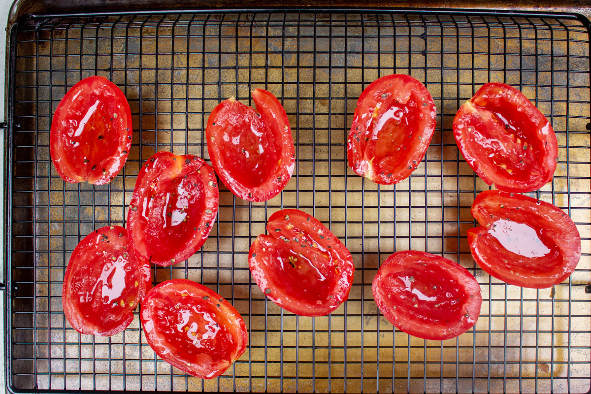 tomato halves seasoned on wire rack over sheet pan.