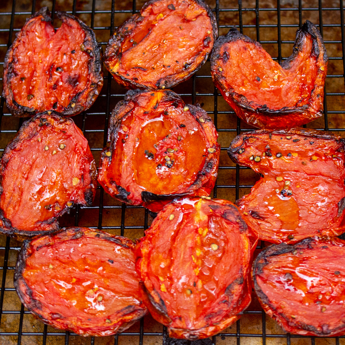 fire roasted tomatoes sitting on wire rack over baking sheet. 