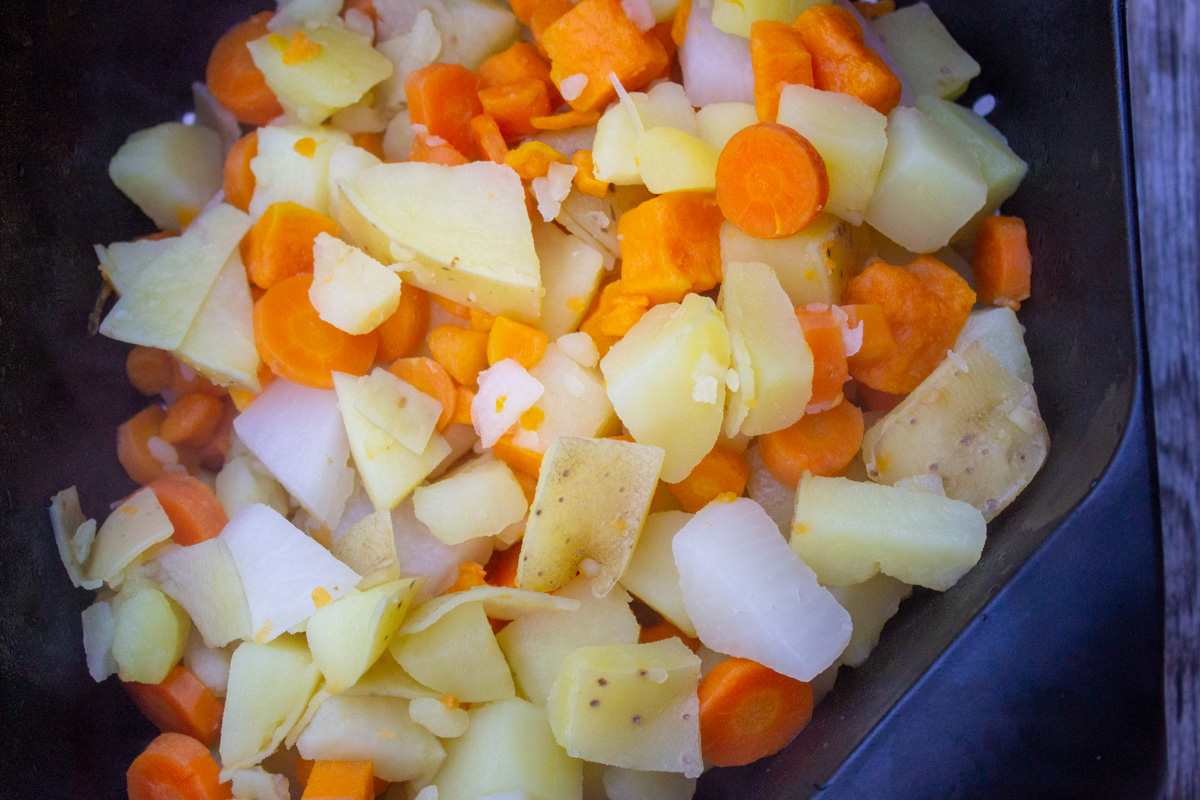 cooked root vegetables in colander, draining.