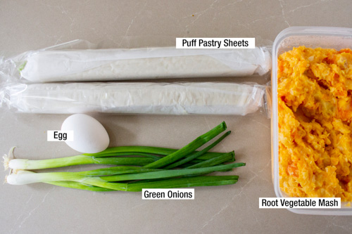 two puff pastry sheets, green onions, one egg and container of root vegetable mash.