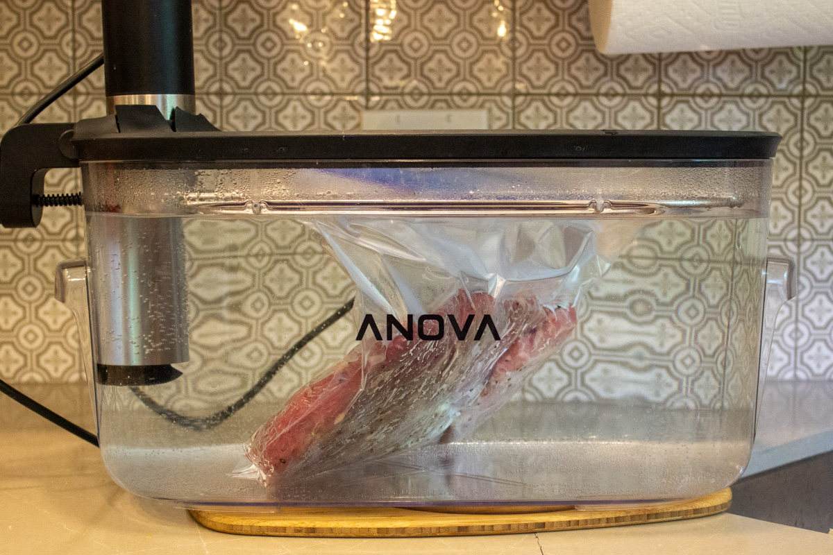 bagged brisket floating in water bath in sous vide container