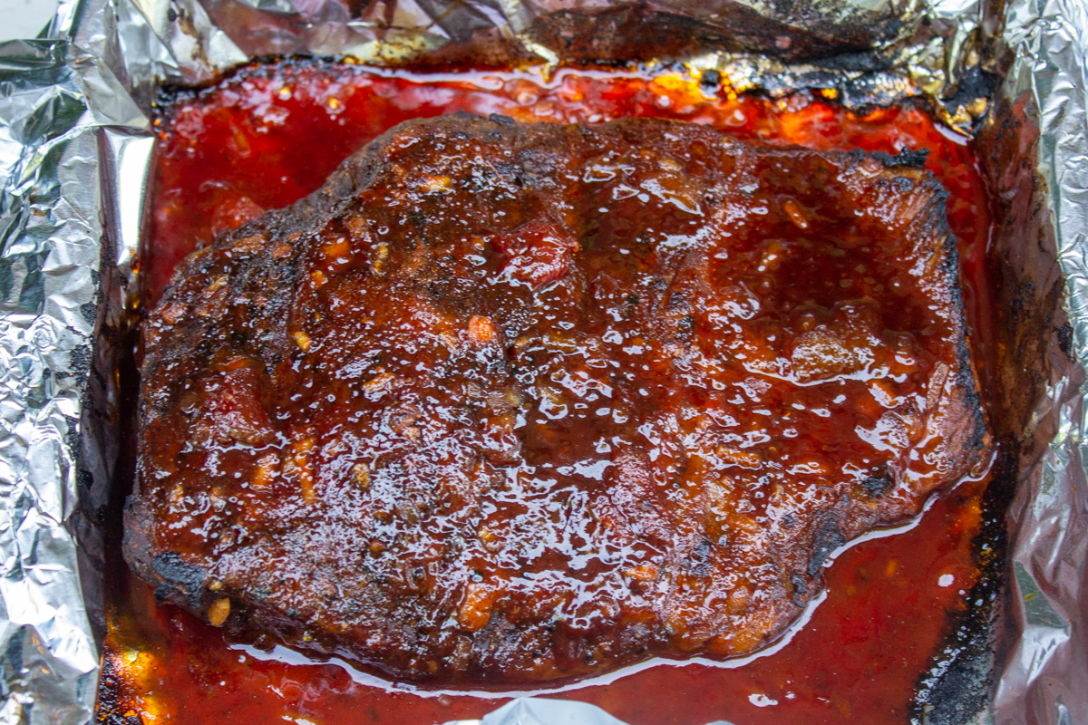 brisket glazed with sauce after broiling in pan.