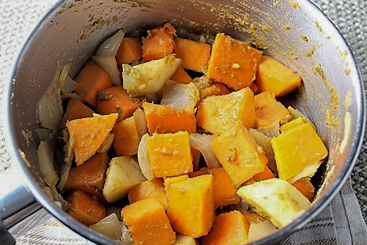 onion, squash and potato with curry paste in pot.