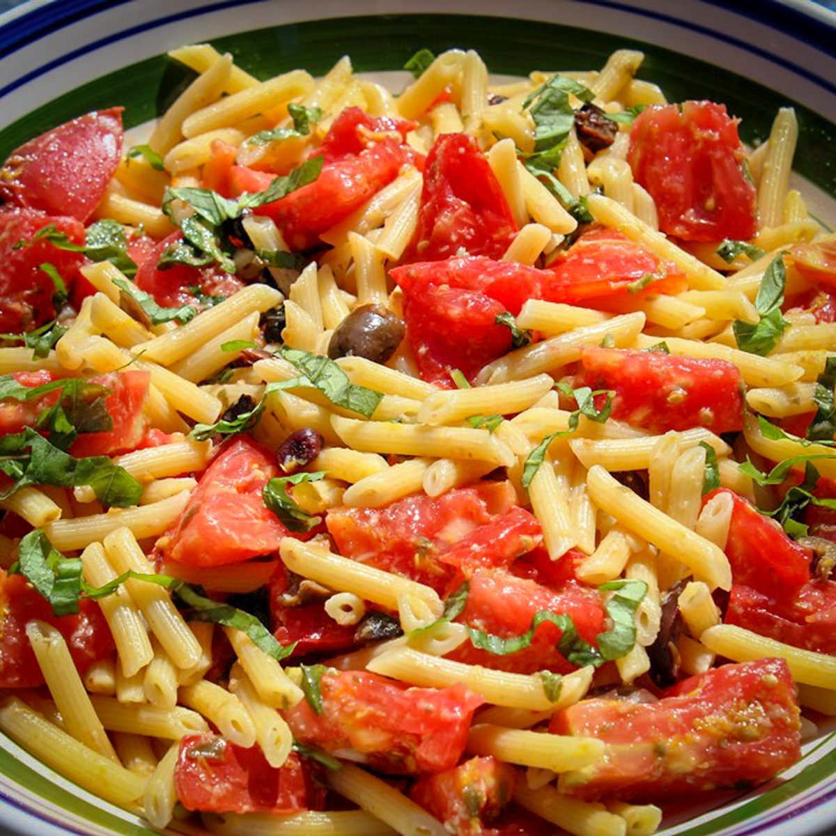 tomato basil pasta with olives and lemon in serving bowl.