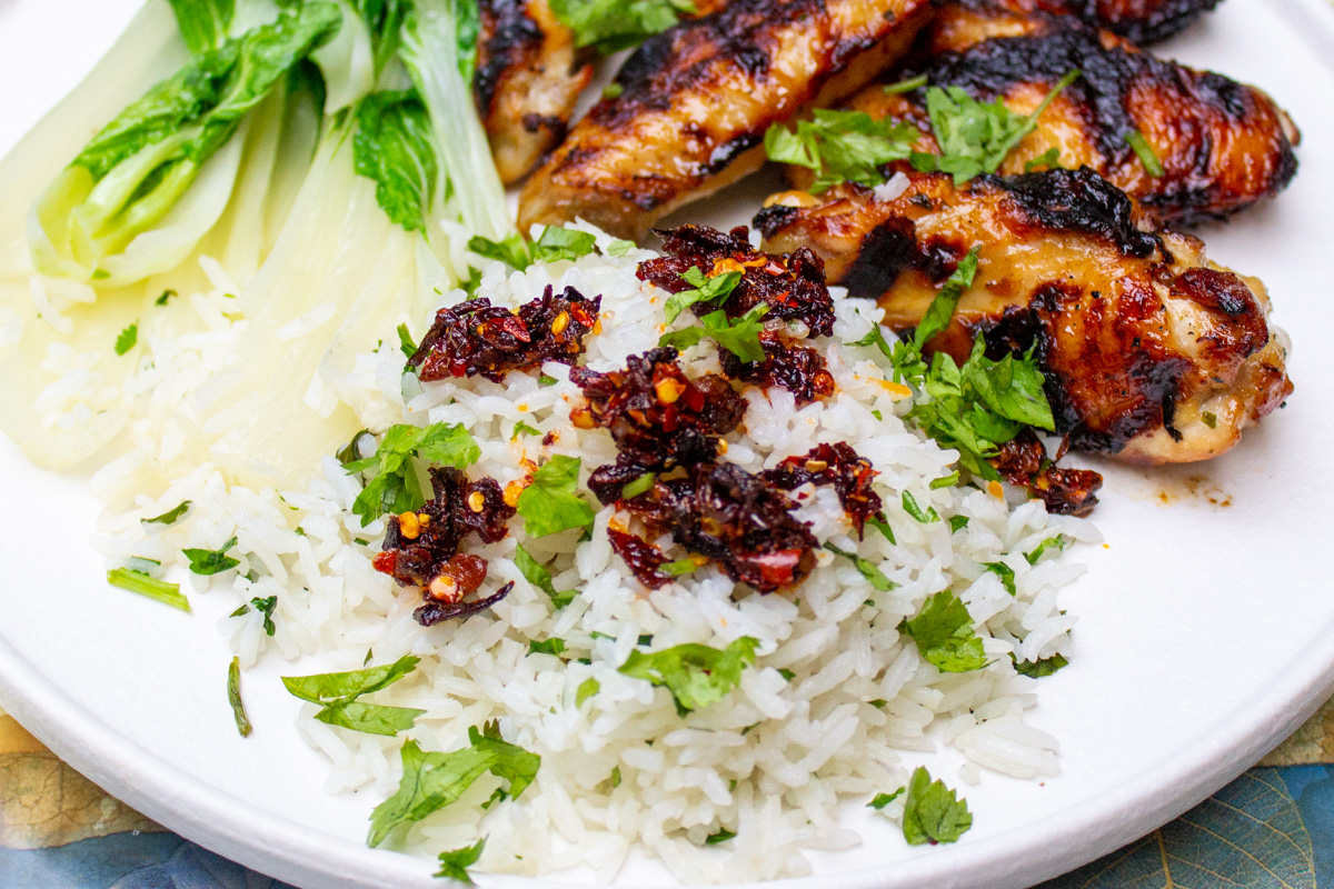 coconut jasmine rice on plate with chicken wings and bok choy.