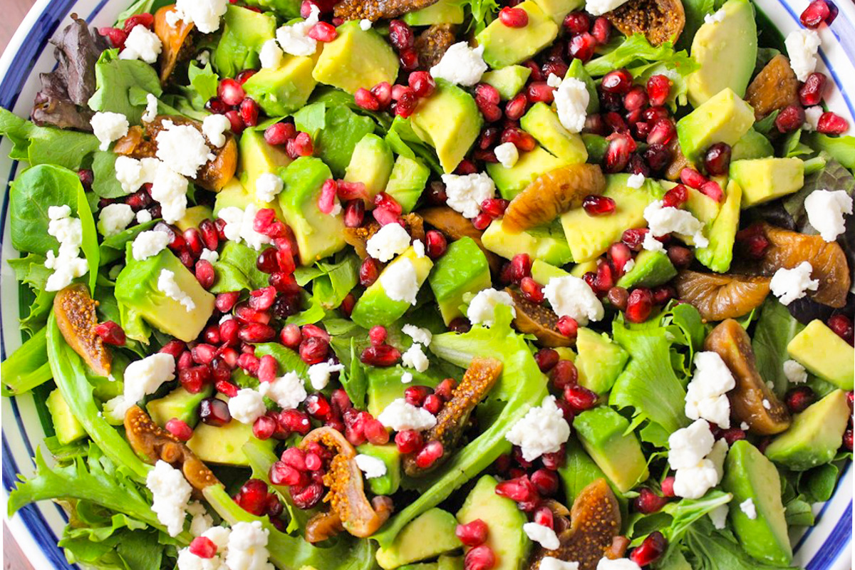 fig salad with pomegranates and avocado and goat cheese on top. 
