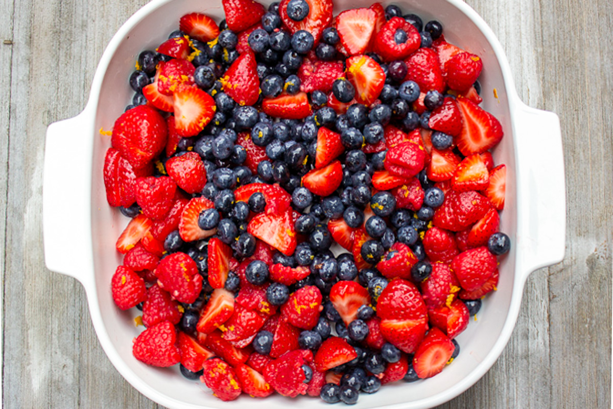 mixed fresh berries in a white serving dish. 