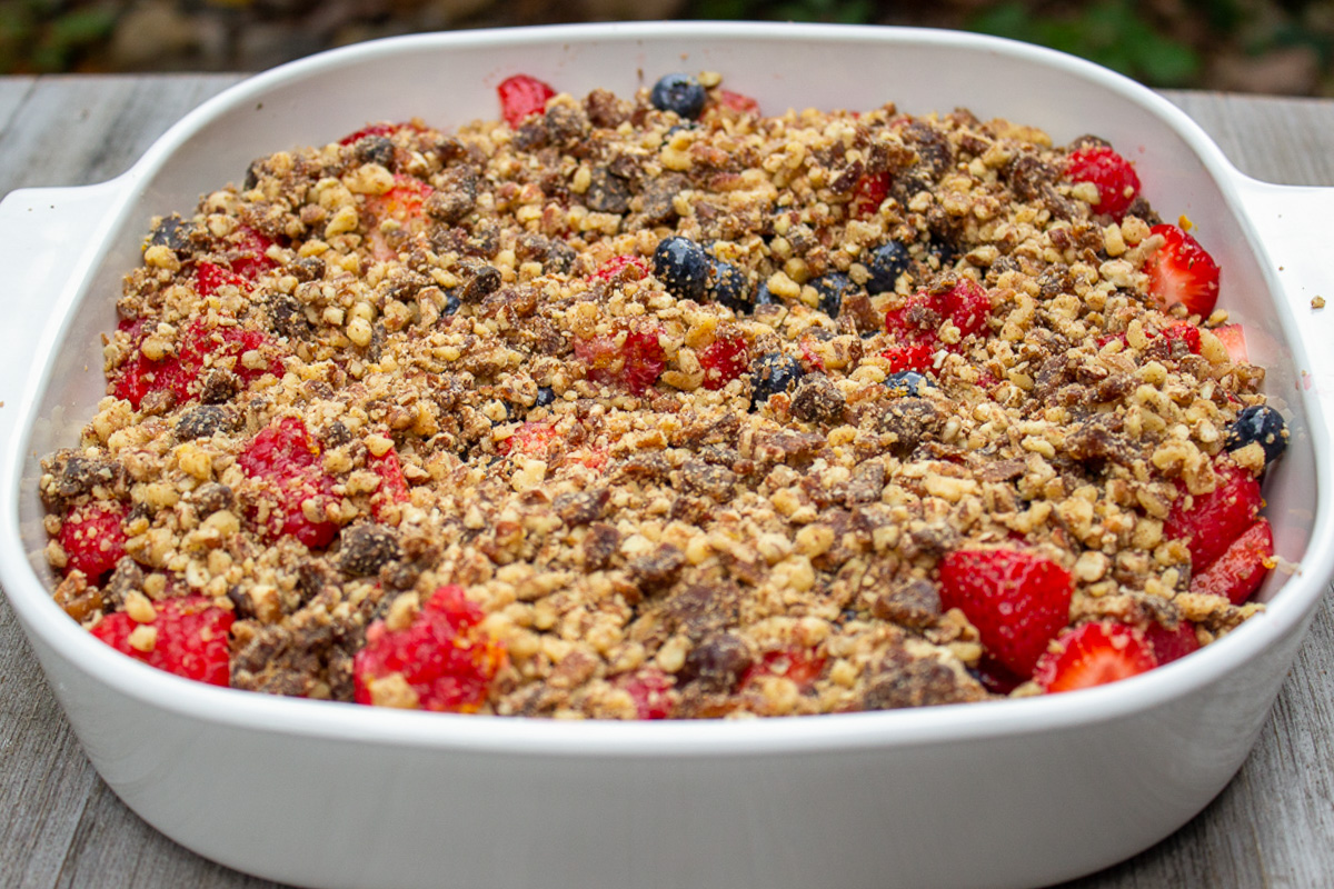 berries topped with a date-nut mixture in serving dish.