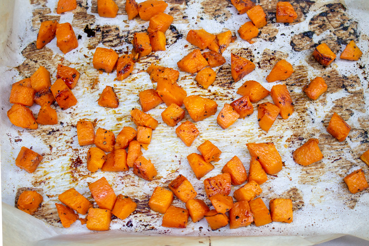 diced roasted pumpkin on baking tray lined with parchment.
