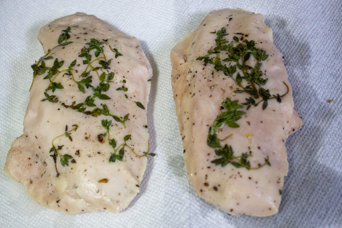 cooked sous vide chicken breasts on cutting board.