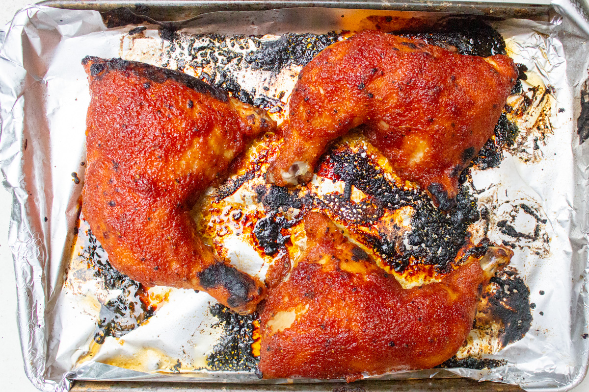 finished glazed chicken leg quarters on baking pan.