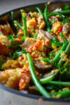 finished paella with green beans in skillet.