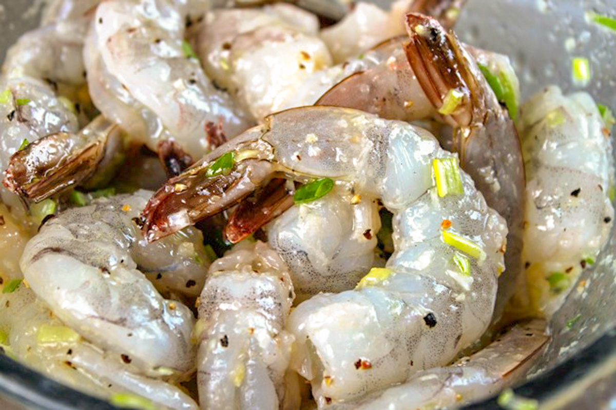 raw shrimp marinating with lemon, oil, garlic and green onion.