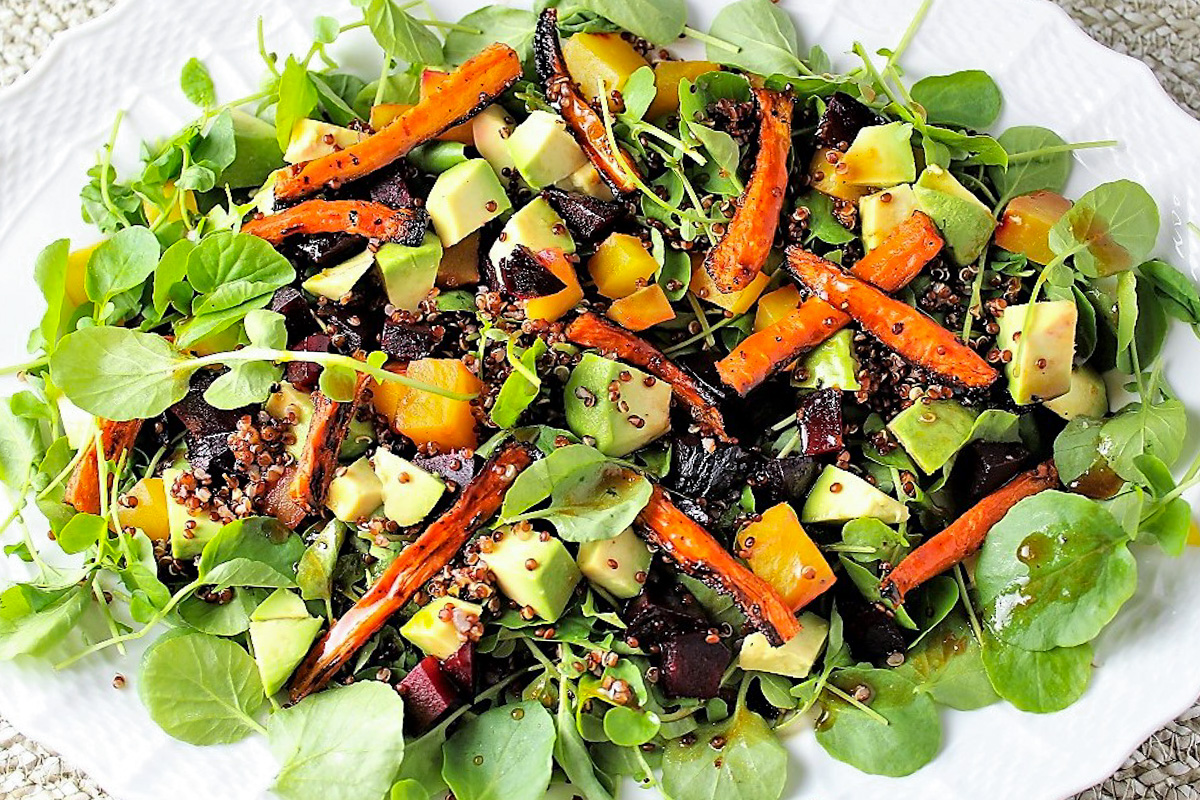 quinoa avocado salad with roasted carrots and beets on white plate.