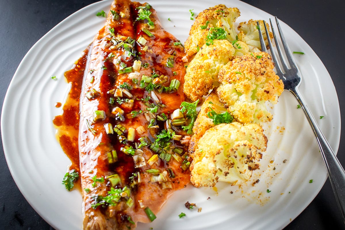 maple balsamic glazed trout on plate with roasted cauliflower.