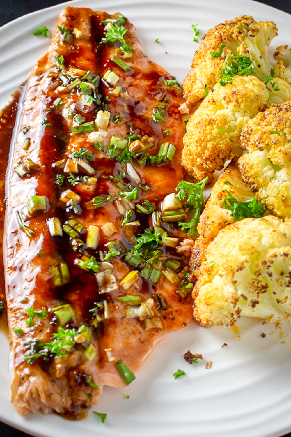 maple balsamic glazed trout on plate with roasted cauliflower.
