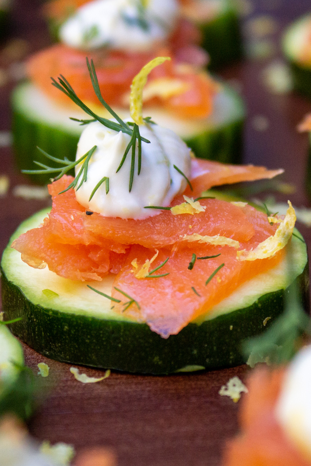 smoked salmon canapes on cucumber garnished with dill and lemon zest.