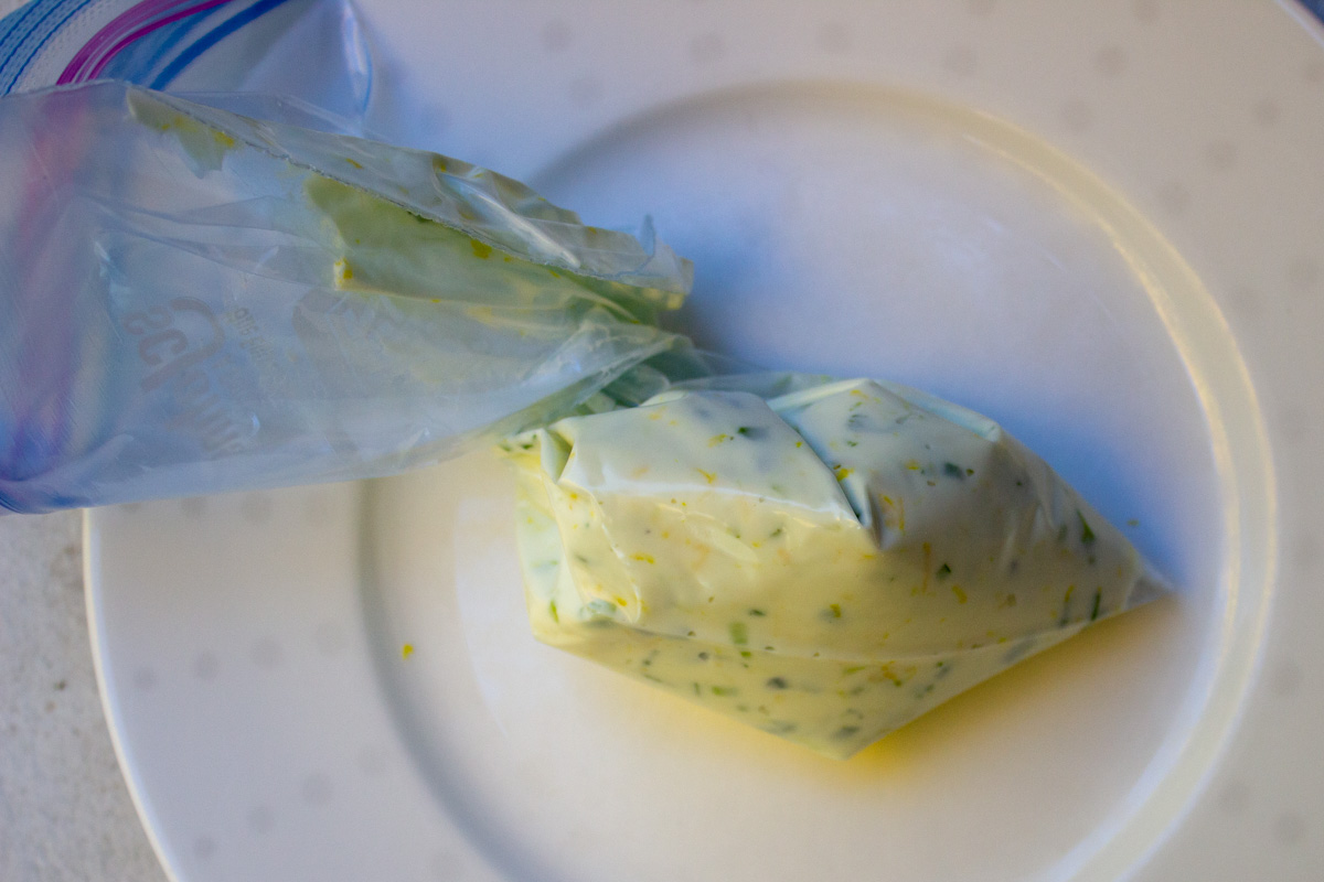 cream cheese mixture in ziploc bag on plate.
