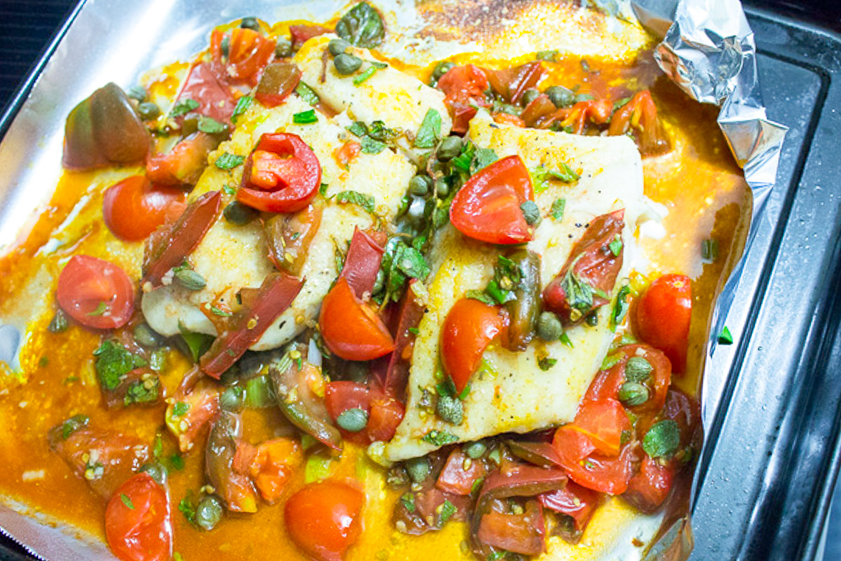 pan seared halibut with tomato caper herb sauce on sheet pan.