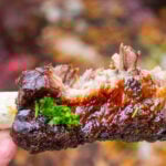 one glazed beef back rib with a bites off the middle.