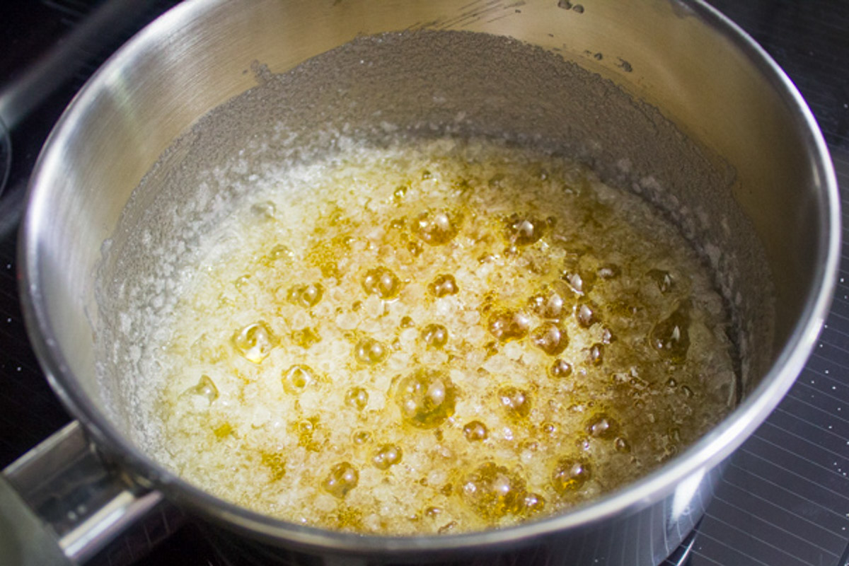 bubbly sugar and water turning to caramel in pot.