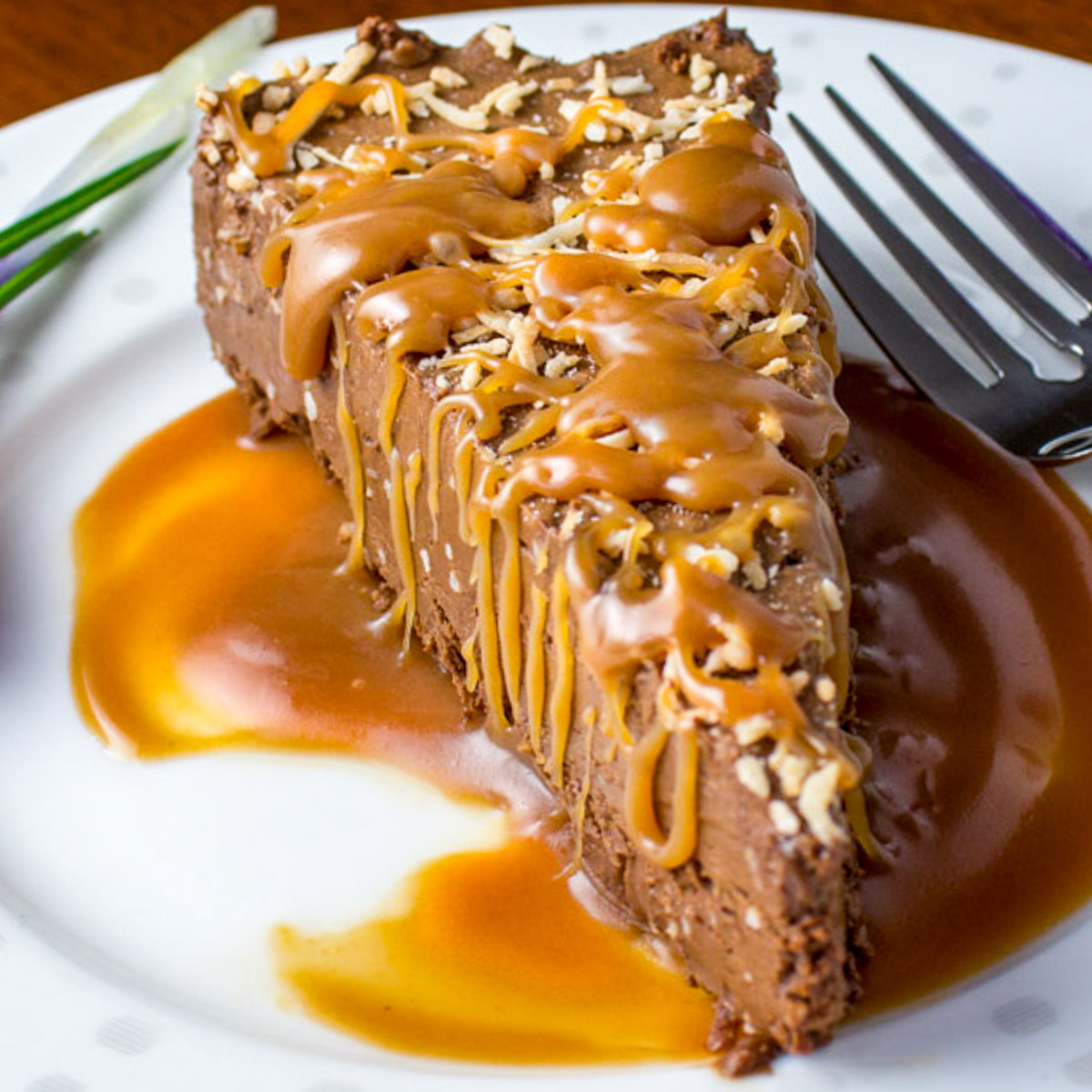 crustless chocolate mousse pie with warm caramel sauce on plate.