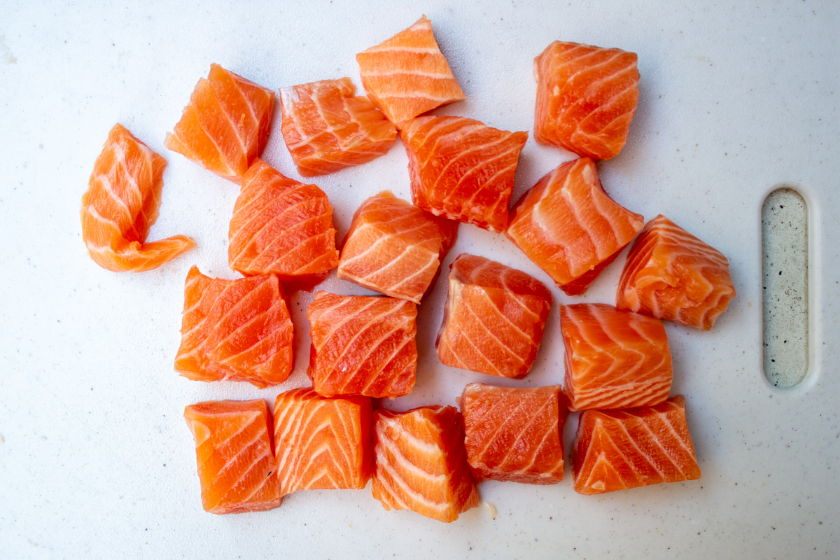 cubes of fresh salmon on cutting board.