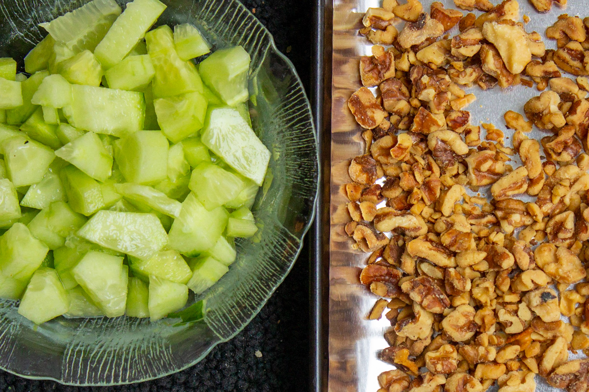 roasted nuts in pan and bowl of diced cucumber.