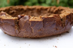 Bread bowl from pumpernickel with slices cut on sides.
