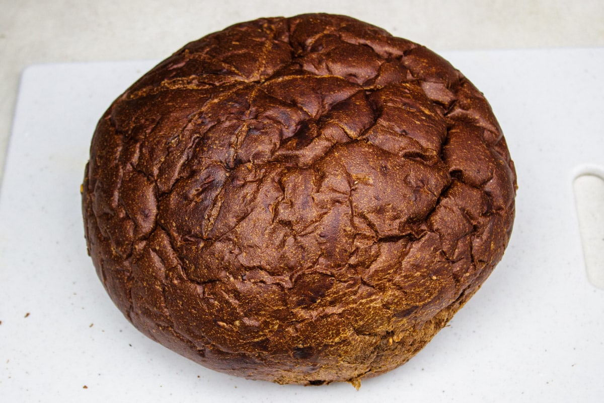 round pumpernickel bread on cutting board.