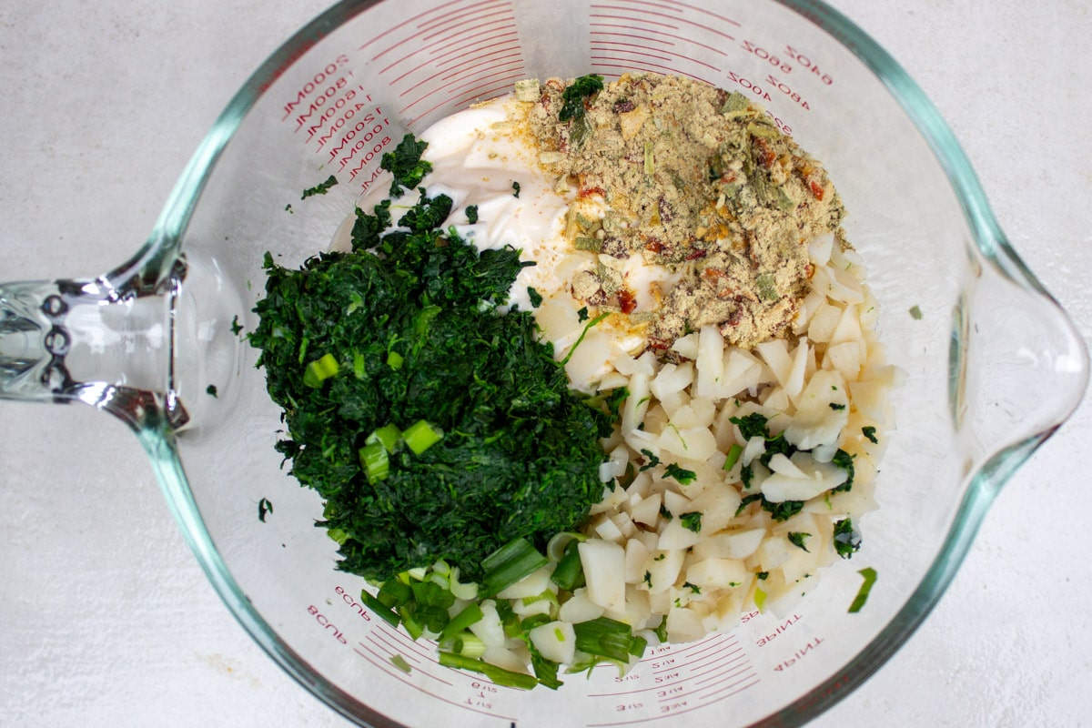 spinach dip ingredients, unmixed, in mixing bowl.