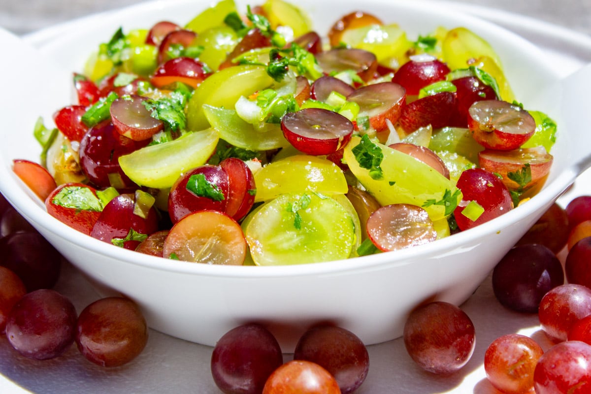 fruit salsa in bowl with grapes in front.